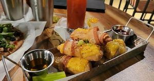 Gluten Free Bamboo Bone-in Large wings (drumsticks) made with Non-GMO soy protein covered in Violife Smoked Provolone cheese perfectly wrapped with Gluten Free Bacon, seasoned with at Pythagoras Conscious Food Philosophy in Houston