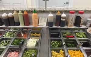 Serving table where you choose Tofu and fish, topping and mix-ins, sauces, etc. at Kai Poke in Huntington