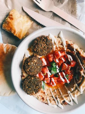 Hummus bowl with tomatoes and falafel. Baklava on the side.  at Simply Hummus Bar in Darlinghurst