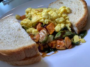 Sweet Potato & Brussels Sprout Hash w/ Red Onions, Dried Cherries, Vegan Eggs, Balsamic Reduction served with choice of Vegan Toast (English Muffin Toast here) at Anna's House in Kalamazoo