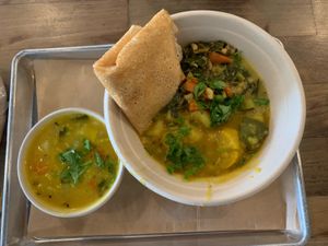 Bowl with two veggies, cup of sambhar at Nourish Wellness Cafe in Costa Mesa
