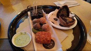 Antipasti misti: tofu fritto, falafel, olive ascolane e bocconcini di mais al carbone. Arancino di riso venere. at HUG at Turnè in Monza