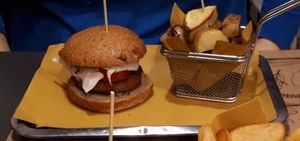 Beyond Burger - Bread containing Beyond Meat (100% vegan), fresh tomatoes, red onion rings and lettuce with a baked potatoes side. at WellDone Burger - Caprarie in Bologna