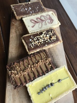 Conscious Cravings tarts: lemon  lavender, espresso hazelnut, peanut butter crunch, raspberry white chocolate and salted caramel. at Love Madre in Cheltenham