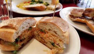 Vegan bahn mi sandwich and vegan macaroni & cheeze with broccoli in the background, and some garlic bread on the side at Herbivore - Mission District in San Francisco