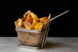 Baked Potatoes - fresh potatoes from the garden, cutted with peel and sauté in the oven with rosemary and poached garlic  at WellDone Burger in Ferrara