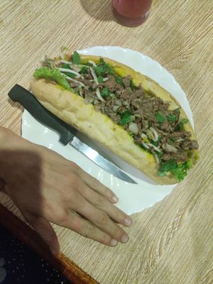Larb sandwich (hand for scale) at Kapphet Vegan in Vang Vieng