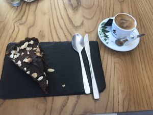 Postre: café con leche de avena y tarta de chocolate at DaTerra in Aveiro