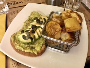 Avocado toast con contorno di patate al forno at WellDone Burger in Ravenna