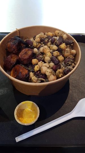 Vegan yassa bowl with (extremely!) hot sauce in the foreground at Osè African Cuisine in Paris