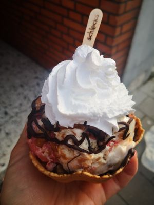 Vegan: halb Vanille halb Erdbeer, cookie, brownie, Ersnusscreme, Sahne. Im Boden Krokant😄 at Schlecks in Muenster