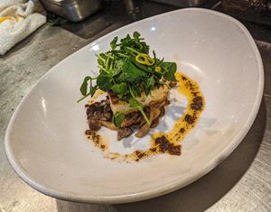 Griddled turnip rice cake over miso clamshell & oyster mushrooms, drizzled w/ fermented black bean chile orange oil, topped w/ pea shoot-pickled ginger-shredded snap pea salad. at Millennium in Oakland