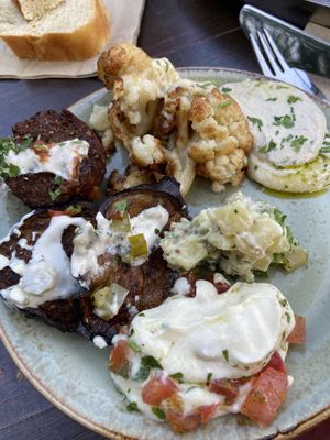 Vorspeisenplatte mit Kartoffelsalat, hummus, Labaneh, falafel, Aubergine, Blumenkohl und Brot  at Kuli Alma in Frankfurt