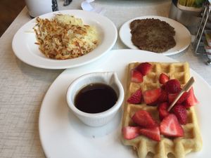 Hash browns, Impossibles meatless sausage patties, gluten free waffle topped with strawberries  at Anna's House in Ann Arbor