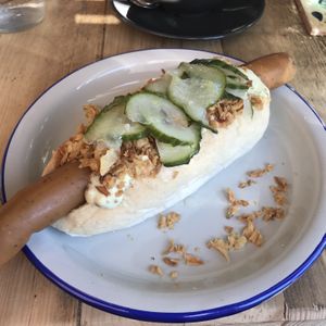 Vegan hot dog with remoulade, picked cucumber and crispy onions at Lion's Den in Haslemere