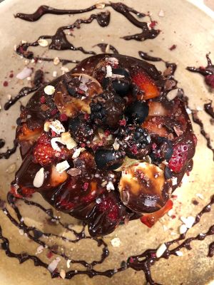 Pancakes with vegan nutella, banana & berries and chocolate syrup at Odacova in Barcelona