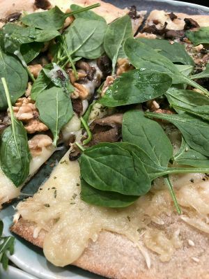 Pizza with AMAZING vegan mozzarella, oregan, spinach, nuts and mushrooms at Odacova in Barcelona