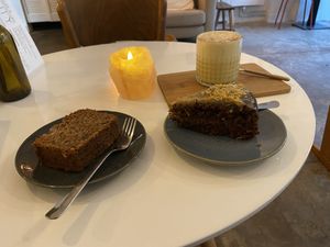 Banana bread (quite nice), carrot cake (very good and moist) and golden latte (very good) with a small piece of tahini square (quite nice)  at Plenty in The Hague