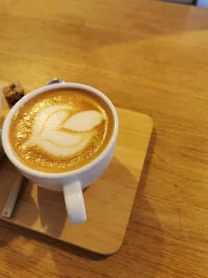 Delicious flat white with a little but very tasty piece of cake at Plenty in The Hague