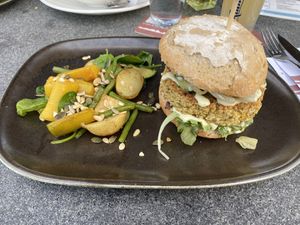 The quinoa-fennel burger with parsley-lemon mayonaise. On the side there is carrot, green beans, potatoes, zucchini and some assorted seeds.  at Brasserie BLVD in Vlissingen