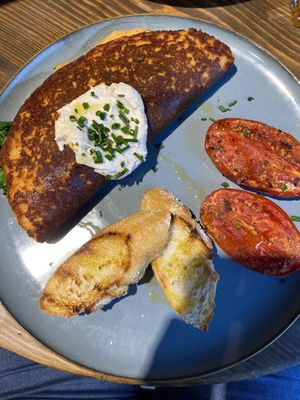 Chickpea omelette with grilled tomato and buckwheat bread at Eqvilibrivm Cafe in Barcelona