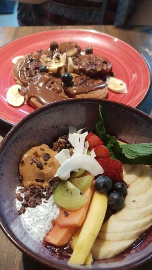 Super Bowl with acai, granola, fruit, peanut butter, chia seeds, cacao nibs. Banana and chocolate spelt pancakes. at Eqvilibrivm Cafe in Barcelona
