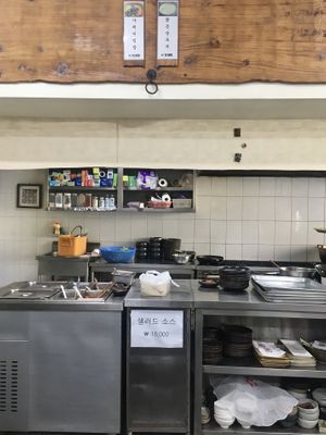 Kitchen and menu on top (only 2 items: bibimbap and tofu stew)  at Babiboyak in Jeju