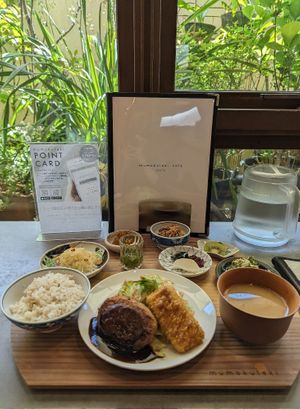 Set with miso soup, tofu hamburger steak, miso cutlet, salads, a shot of juice and a bit of friit at Mumokuteki Vegan Cafe in Kyoto