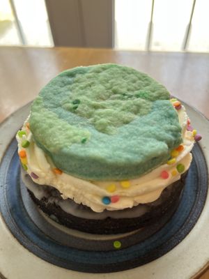 Earth Days donut for #PlantedForThePlanet, chocolate cake donut, vegan buttercream cloud, vegan butter cookie and rainbow confetti. plantedfortheplanet.org  at Lovebirds Donuts in Kittery