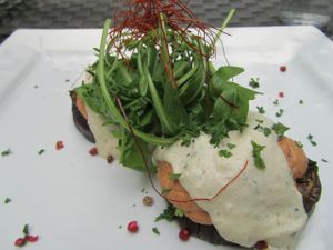 baked eggplant rounds topped with tofu Bolognese, cashew crème, on bed of greens at La Mano Verde in Berlin