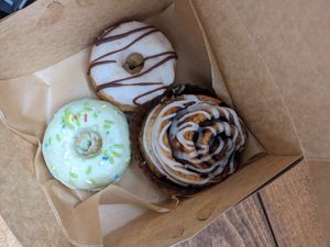 Vanilla mint donut, somoa donut, and cinnamon roll. at Happy Bellies Bake Shop in Appleton