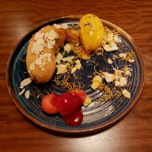Deep-fried banana served with almonds, strawberries and mango sorbet. at Waipo in Stockholm