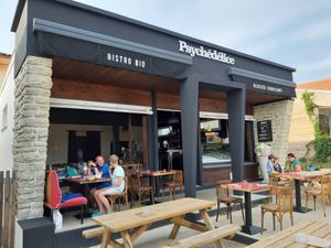 Draußenbereich vor dem Restaurant mit Picknickbänken und Bestuhlung. at Psychédélice in Saint-julien-en-born