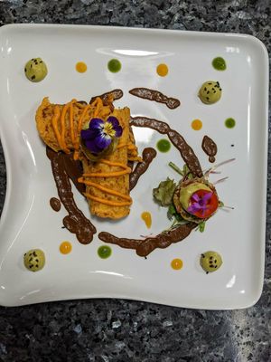 Flautas made of mote (corn) filled with shredded mushroom served on chocolate mole and a pumpkin seed tomato salsa at The Culinary Alchemists in Nuevo Arenal