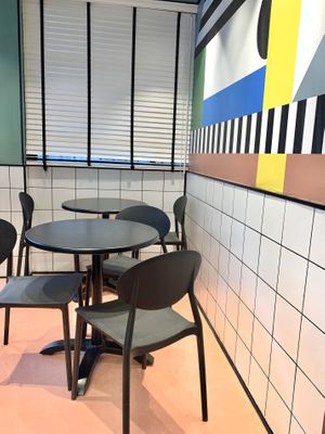 Seating in the colorful dining area - drink lemonade and think about the Bauhaus. at The Green Butcher in Tel Aviv