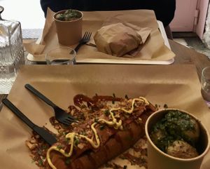 Burger and hot dog with roasted potatoes with chimichurri as a side  at Wholywood in Paris