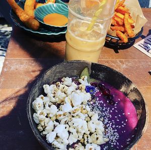Sweet potato fries, lemon ‘shrimp’, Pink Sky Smoothie Bowl and an iced latte. at Pele Surf Shack in Hook Of Holland