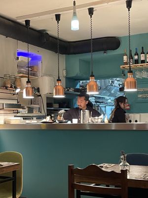 Staff putting beautiful finishing touches on dishes.   at O Gambuzino in Lisbon