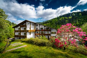 Back of the house with sunbathing lawn at Holzschuh's Schwarzwaldhotel in Baiersbronn