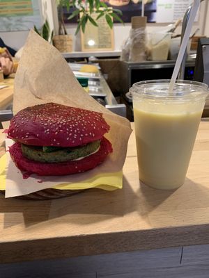 Burger con pane alla rapa rossa, burger di quinoa e verdure, verdure cotte e maionese vegana. Smoothie Sunset.  at Nectare in Bologna