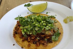 Taco chicharrón after adding salsa, cilantro and lime  at El Bajón Vegano in Tulum