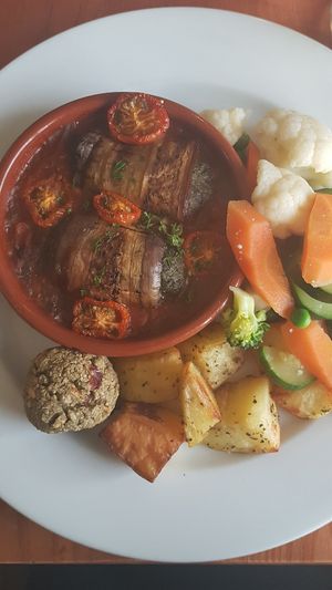 Vegan cream cheese & spinach grilled aubergine rolls in tomato ragout with roast potatoes, steamed veg & stuffing at The Lewiston Loch Ness Inn in Drumnadrochit