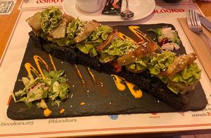 Black focaccia with spinach Hummus and baked potatoes at Sanissimo - Gran Via in Madrid