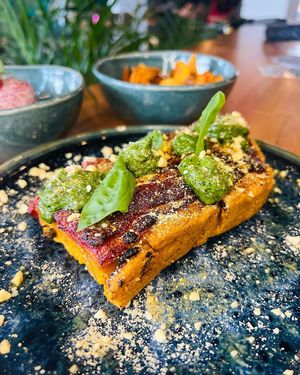 Pizza with pumpkin dough, tomato sauce, green pesto, vegan parmesan, olive oil and fresh basil at MIMO in Malaga