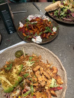 Poke bowl with added seitan, and sweet potato fries in background. at Honest Greens - Serrano in Madrid