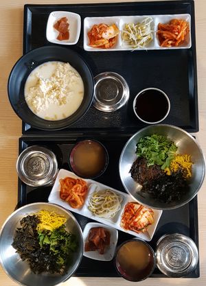 Two types of Bibimbab and vegan Soft Tofu Stew served with rice, soup (contains anchovy broth) and complimentary side dishes (some contain fish-sauce). at Naerincheon Rest Area 내린천 휴게소 in Inje