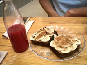 Red juice with Orange, beets, saffron and carrot, and peanut butter & banana on homemade spelt bread. at Natural.mente in Portimao