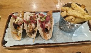 soft tacos filled with crispy sweet potato, slaw, pink pickled onions, crispy onions, spring onions, sage & onion ranch dressing. Served with sage & onion chips (swapped) at Harvester Quayside - Mediacityuk in Manchester