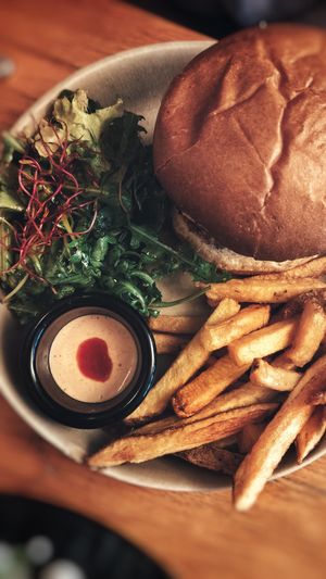 Burger aux champignon shimeji panné, mayo sriracha, aubergines, roquette, coriandre et pickles de moutarde avec frites et salade at Mōpa in Paris