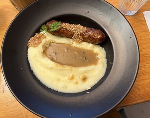 Saucisse purée: sausage over mashed potatoes and gravy  at Mōpa in Paris